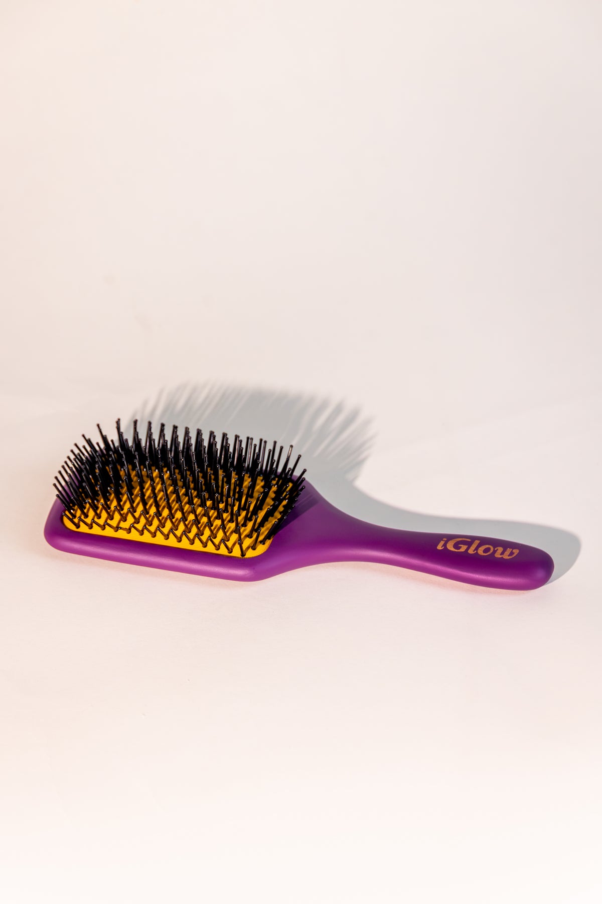 iGlow Paddle Brush sett fra siden med lilla håndtak